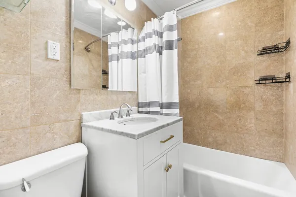 a bathroom with a sink a toilet a mirror and shower