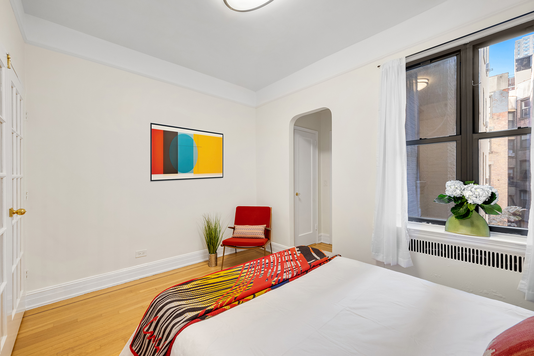 124 East 91st Street, Unit 3D Manhattan, NY 10128 - Photo 6 of 11 a bedroom with a bed and a large window