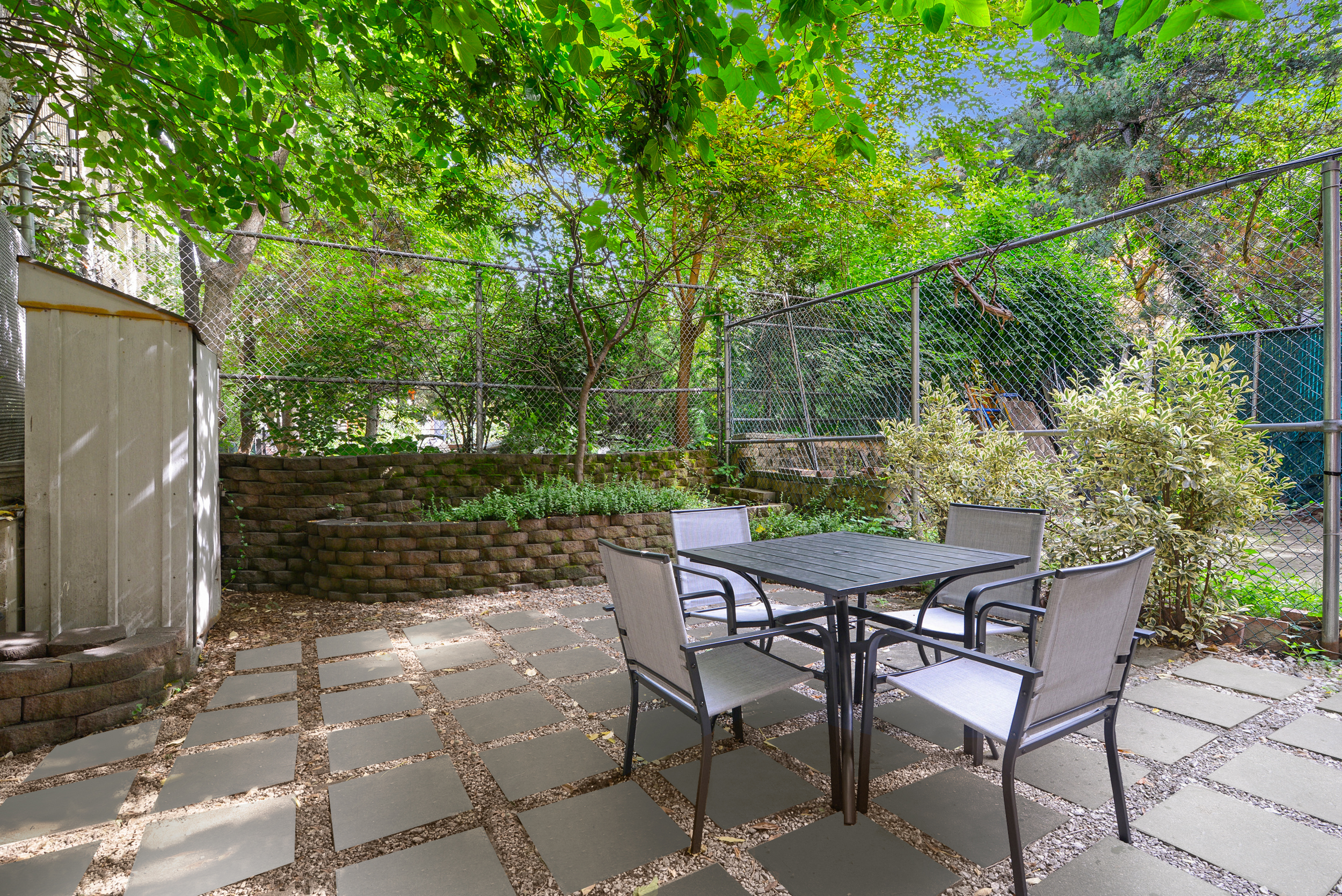 a patio with table and chairs and potted plants
