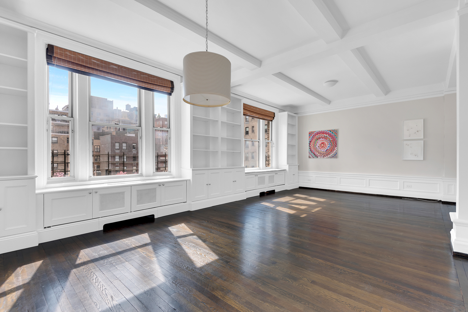 122 East 82nd Street, Unit 8C Manhattan, NY 10028 - Photo 1 of 15 a view of an empty room with a window and wooden floor
