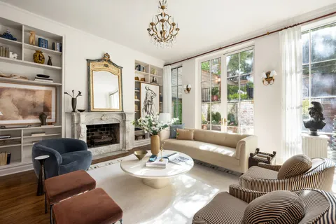 a living room with furniture a fireplace and a large window