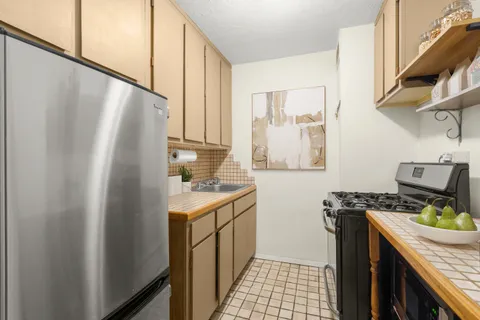 a kitchen with stainless steel appliances granite countertop a refrigerator and a stove