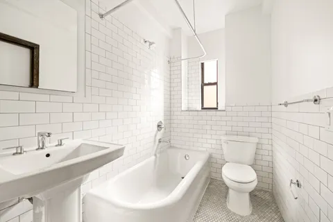 a bathroom with a toilet sink and mirror