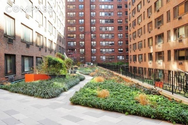 420 East 64th Street, Unit E3A Manhattan, NY 10065 - Photo 7 of 8 a view of a building with a yard and plants