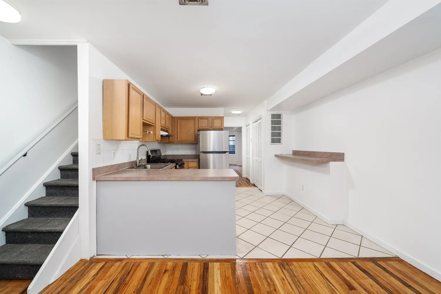 a view of kitchen with kitchen island microwave stove refrigerator and cabinets