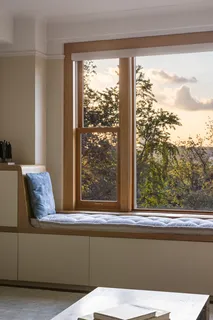 a living room with a large window and a bed