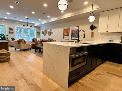 a kitchen with kitchen island granite countertop a sink and white cabinets
