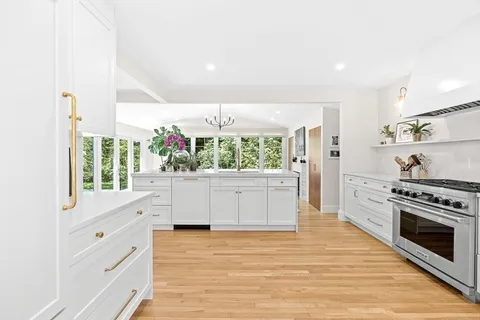 a kitchen with white cabinets and window