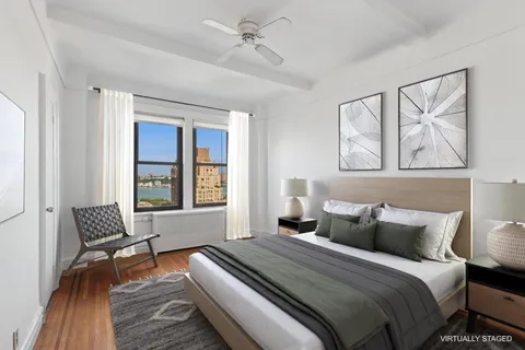 an empty room with wooden floor chandelier fan and windows