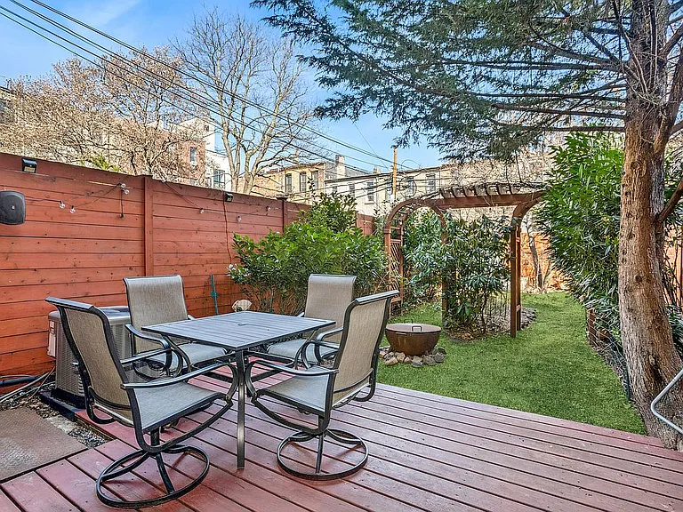 441 MacDonough Street Brooklyn, NY 11233 - Photo 6 of 13 a view of a patio with table and chairs with wooden floor and fence