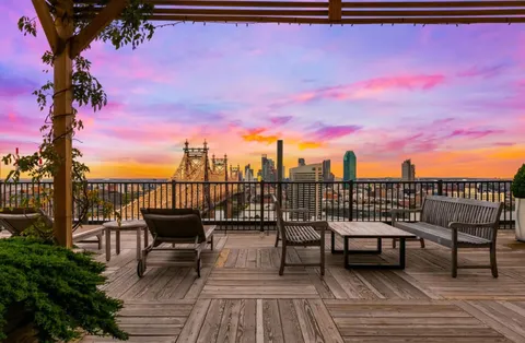 a view of a roof deck with chair and wooden floor