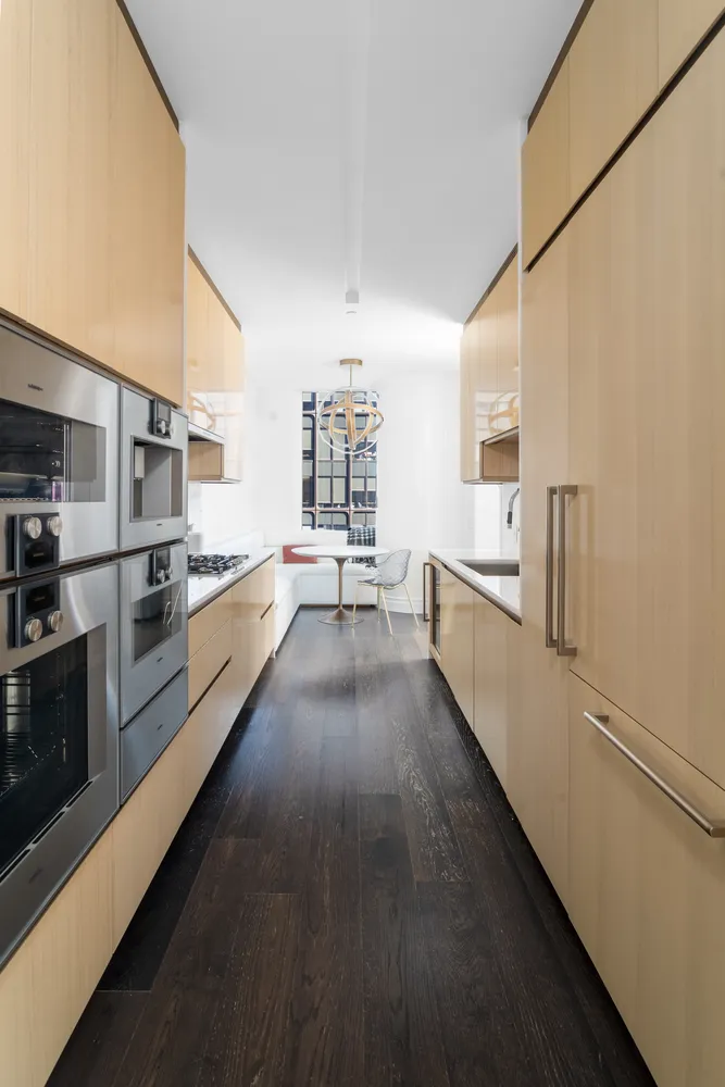 a view of a kitchen with a sink and dishwasher a stove top oven with wooden floor