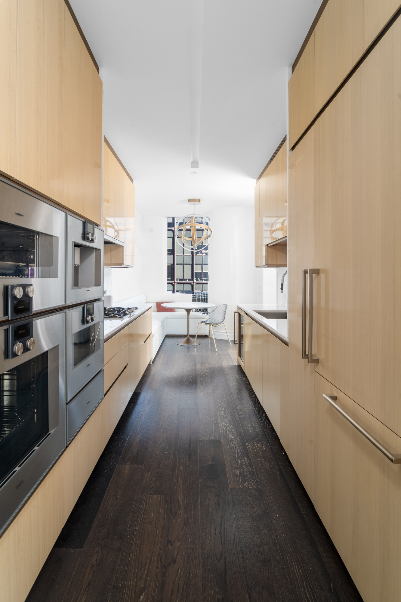 35 Hudson Yards, Unit 5903 Manhattan, NY 10001 - Photo 4 of 15 a view of a kitchen with a sink and dishwasher a stove top oven with wooden floor