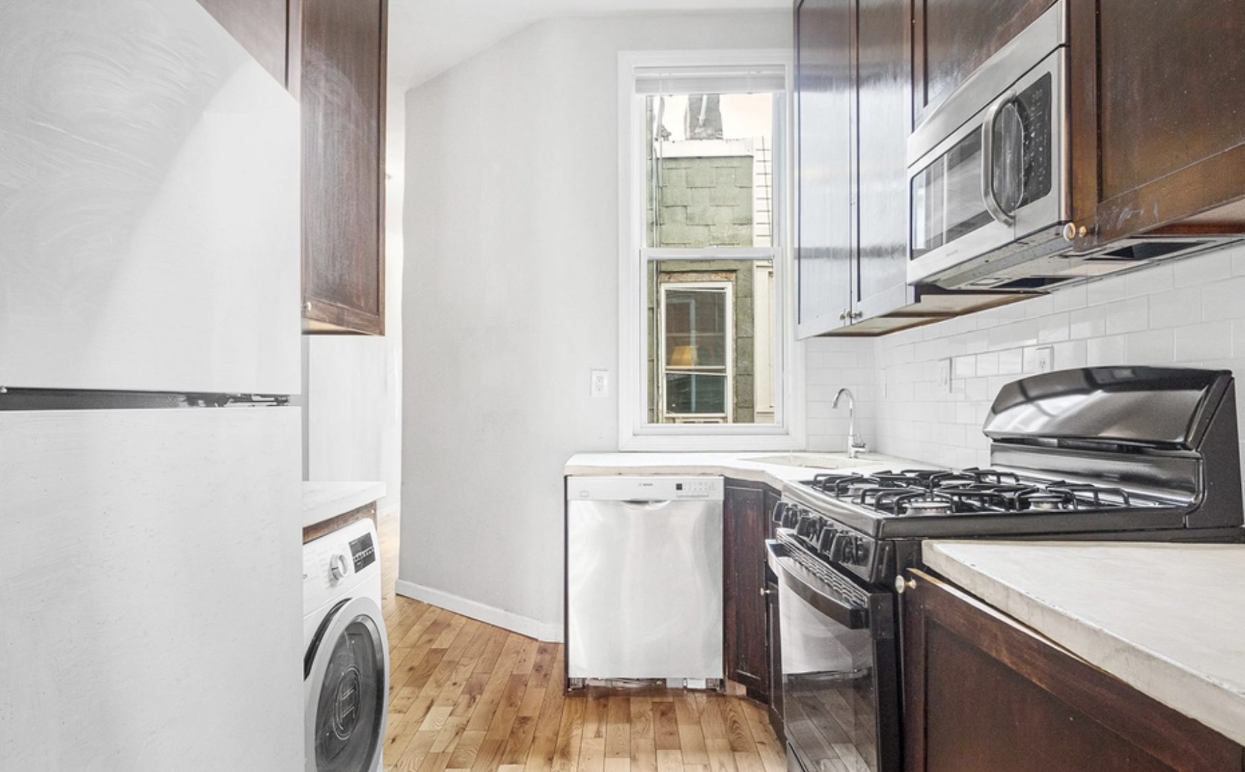 22-18 41st Street, Unit 2R Queens, NY 11105 - Photo 3 of 10 a kitchen with stainless steel appliances granite countertop a stove and a sink