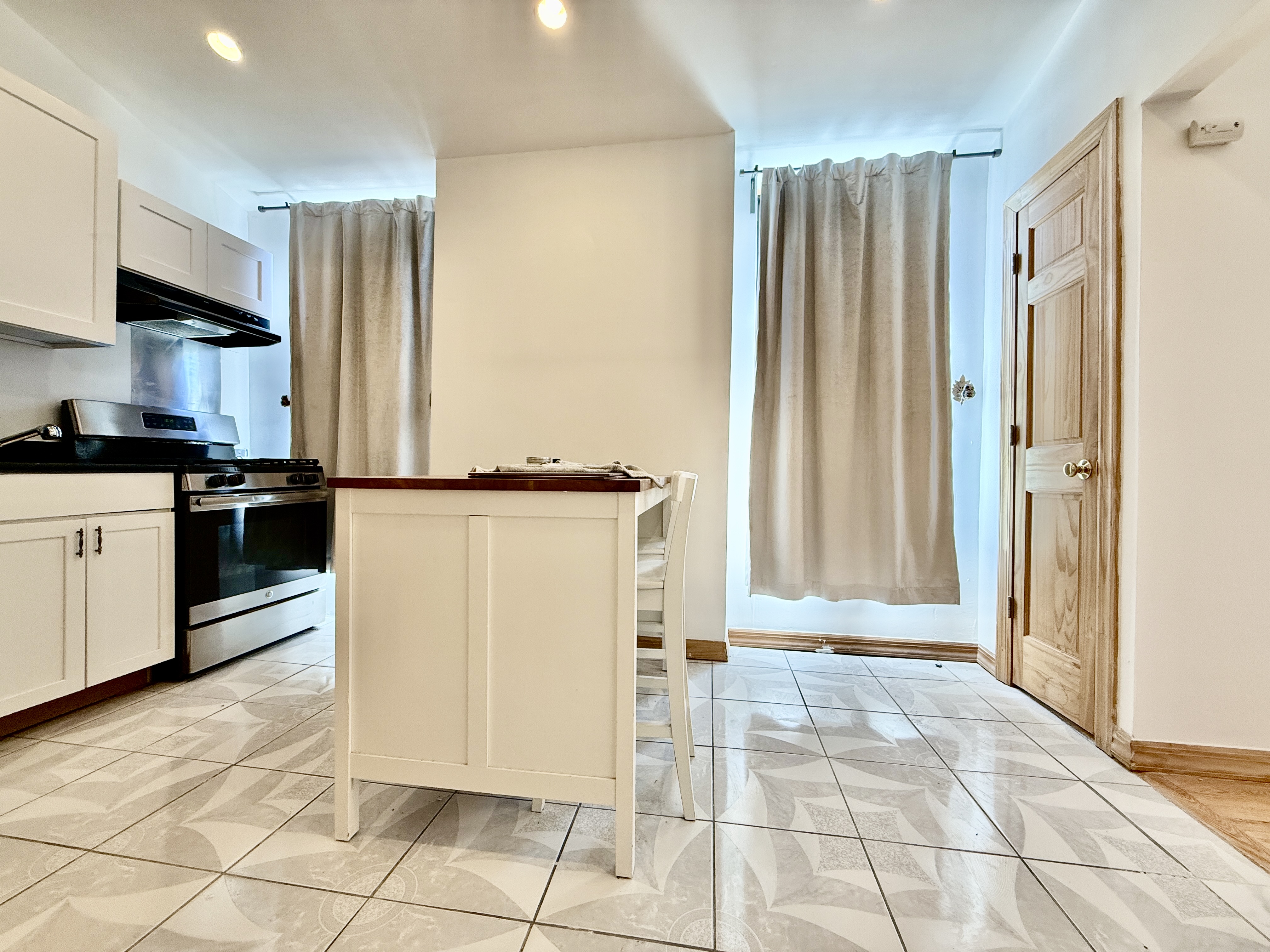 295 Greene Avenue, Unit 2 Brooklyn, NY 11238 - Photo 3 of 6 a kitchen with stainless steel appliances granite countertop a refrigerator and a sink
