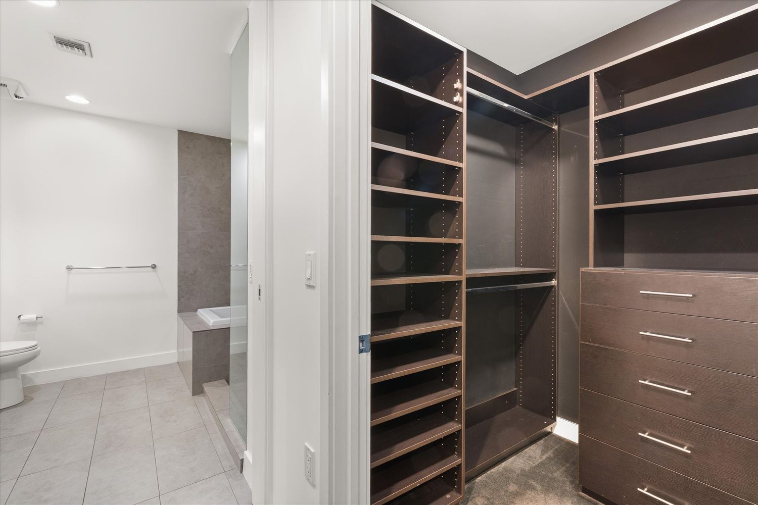 a view of walk in closet and wooden floor