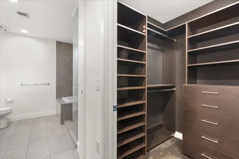 a view of walk in closet and wooden floor