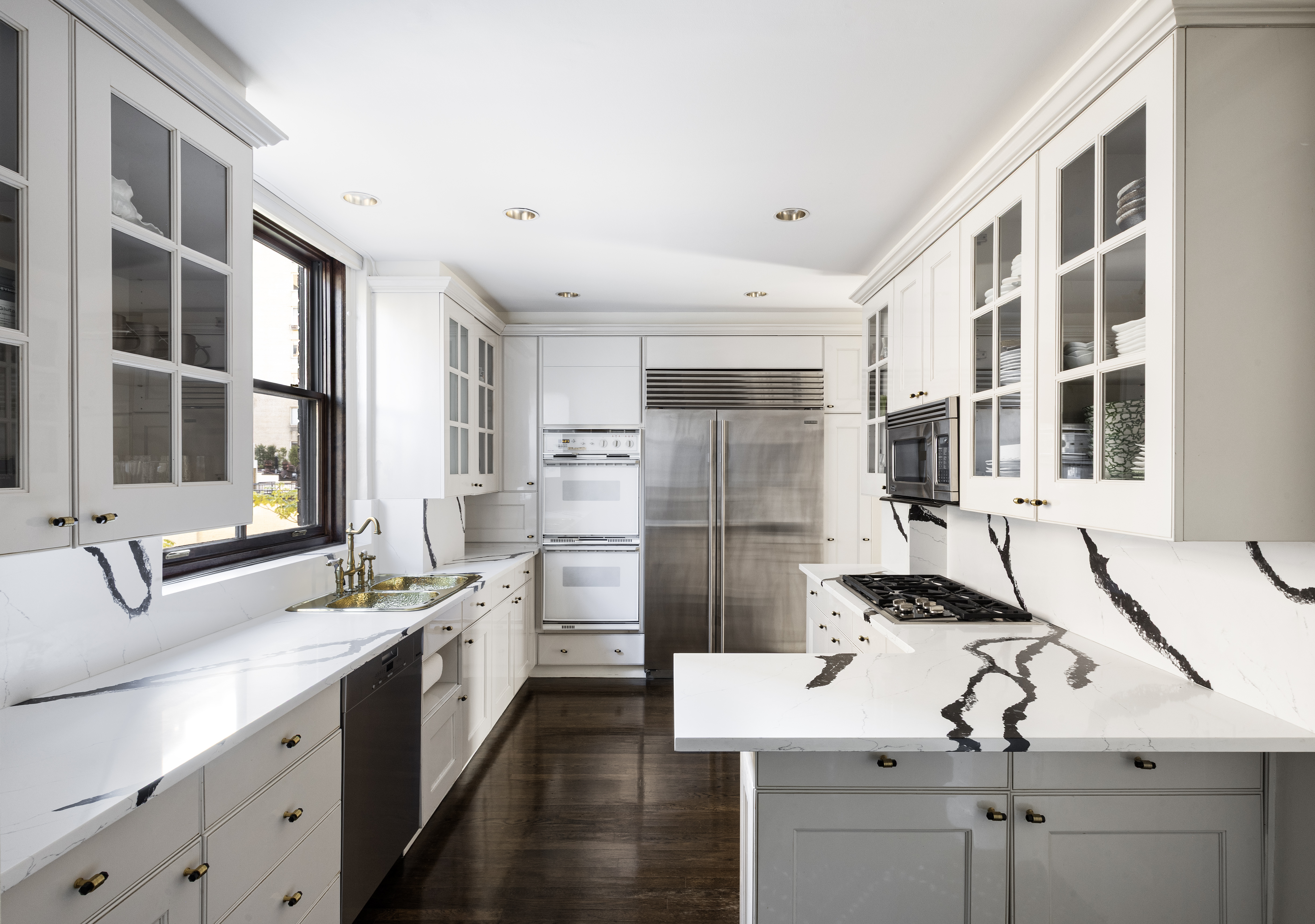 14 East 75th Street, Unit 7E Manhattan, NY 10021 - Photo 9 of 13 a kitchen with stainless steel appliances kitchen island a sink stove and refrigerator