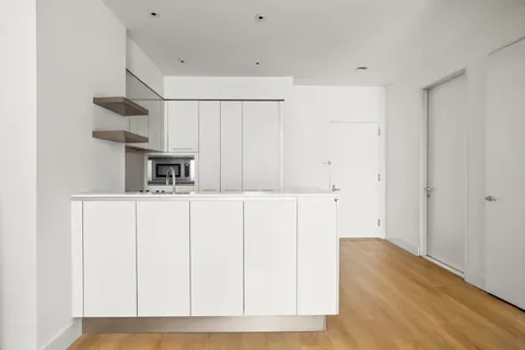 a kitchen with cabinets and wooden floor