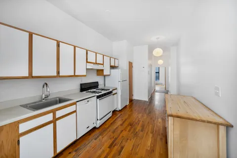 a kitchen with a sink and wooden floor