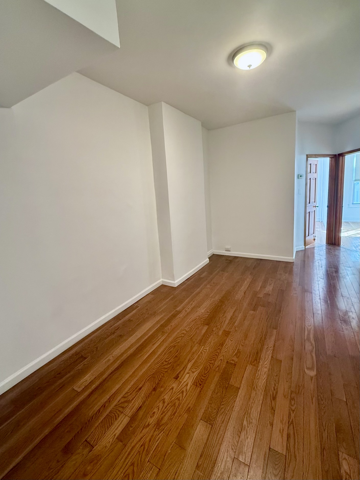 18-48 21st Drive, Unit 1R Queens, NY 11105 - Photo 4 of 11 a view of empty room with wooden floor