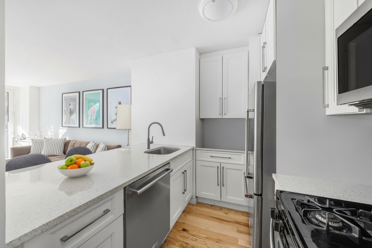 E 47th St, Unit 10H Manhattan, NY 10017 - Photo 2 of 10 a kitchen with stainless steel appliances a sink a stove and a refrigerator