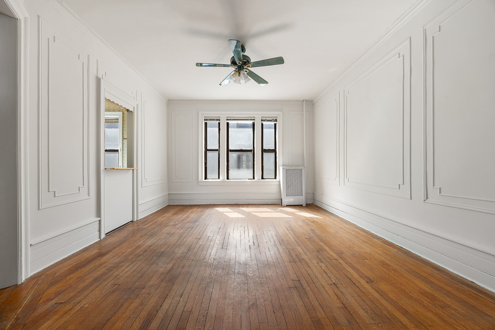 310 Windsor Place, Unit 32 Brooklyn, NY 11218 - Photo 4 of 19 an empty room with wooden floor chandelier and windows