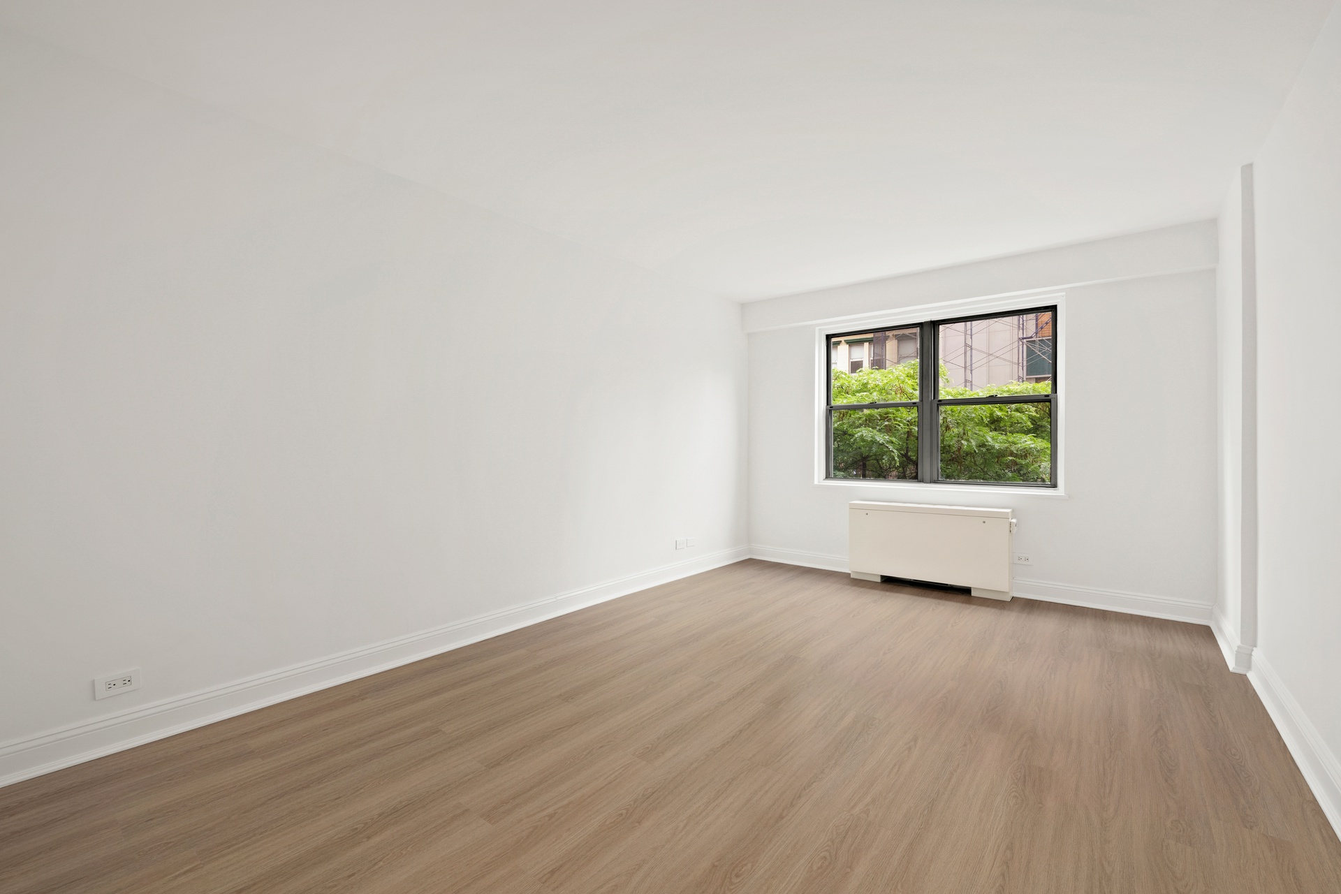 10 West 15th Street, Unit 414 Manhattan, NY 10011 - Photo 7 of 16 an empty room with wooden floor and windows