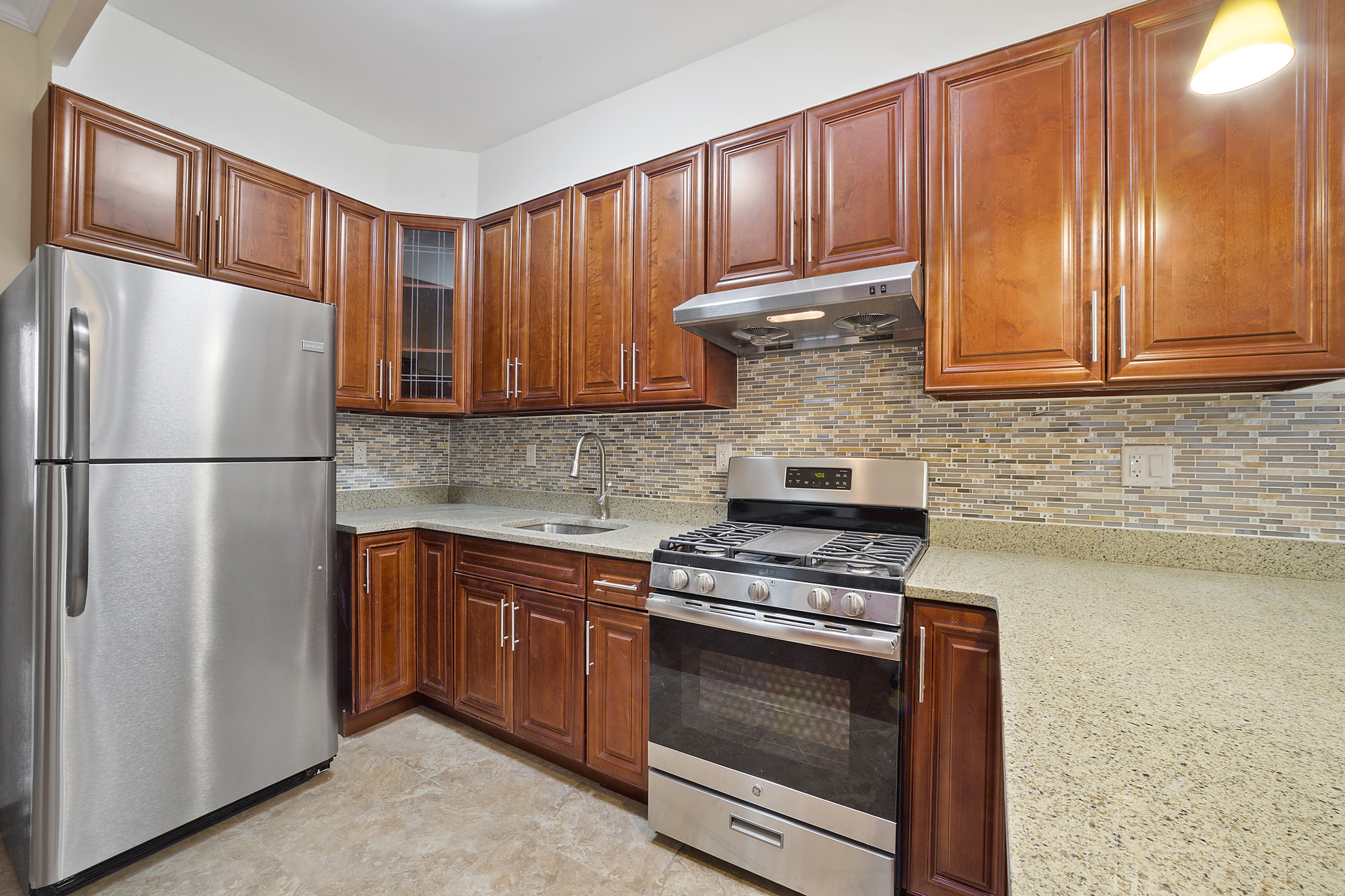 208 Lenox Road, Unit 3 Brooklyn, NY 11226 - Photo 2 of 7 a kitchen with granite countertop wooden cabinets stainless steel appliances and a window