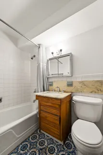 a bathroom with a granite countertop toilet a sink and bathtub