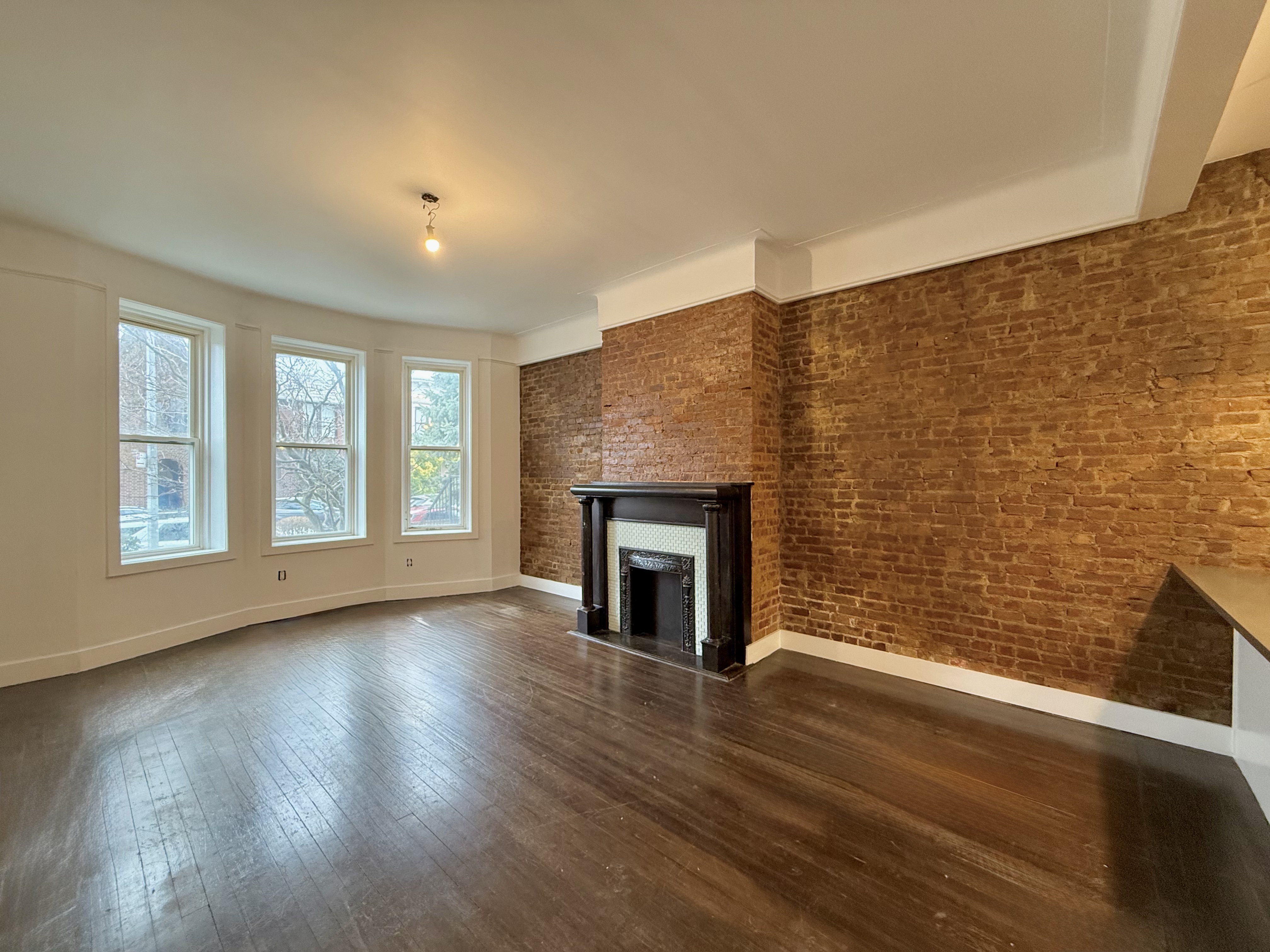 a view of empty room with wooden floor and fireplace