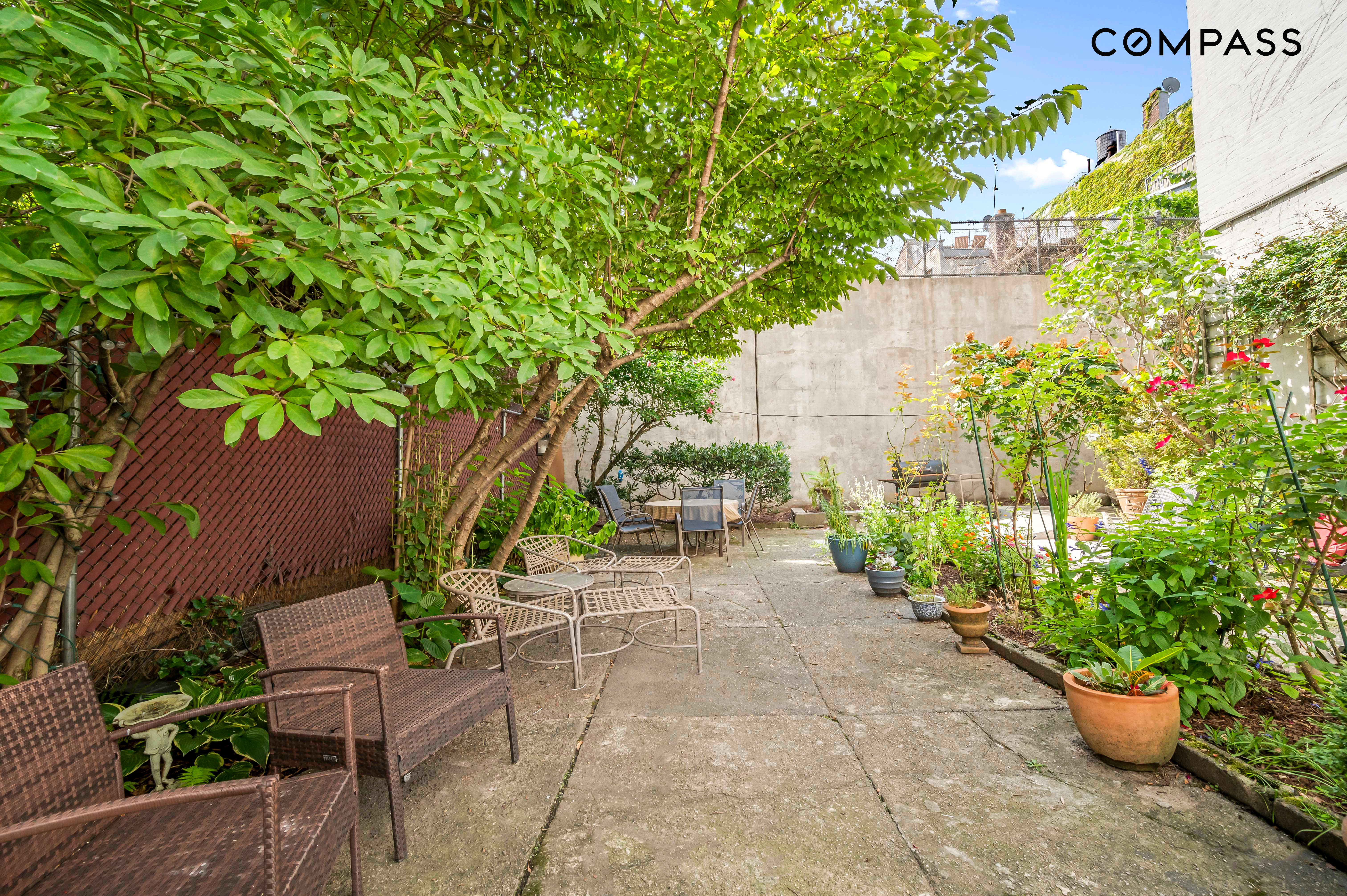 240 East 30th Street, Unit 5B Manhattan, NY 10016 - Photo 6 of 7 a view of a backyard with potted plants and large trees