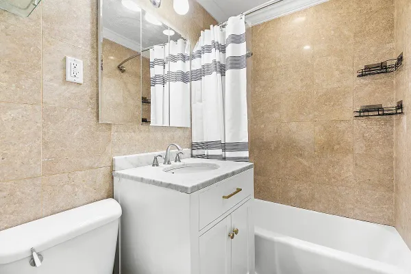 a bathroom with a sink a toilet a mirror and shower