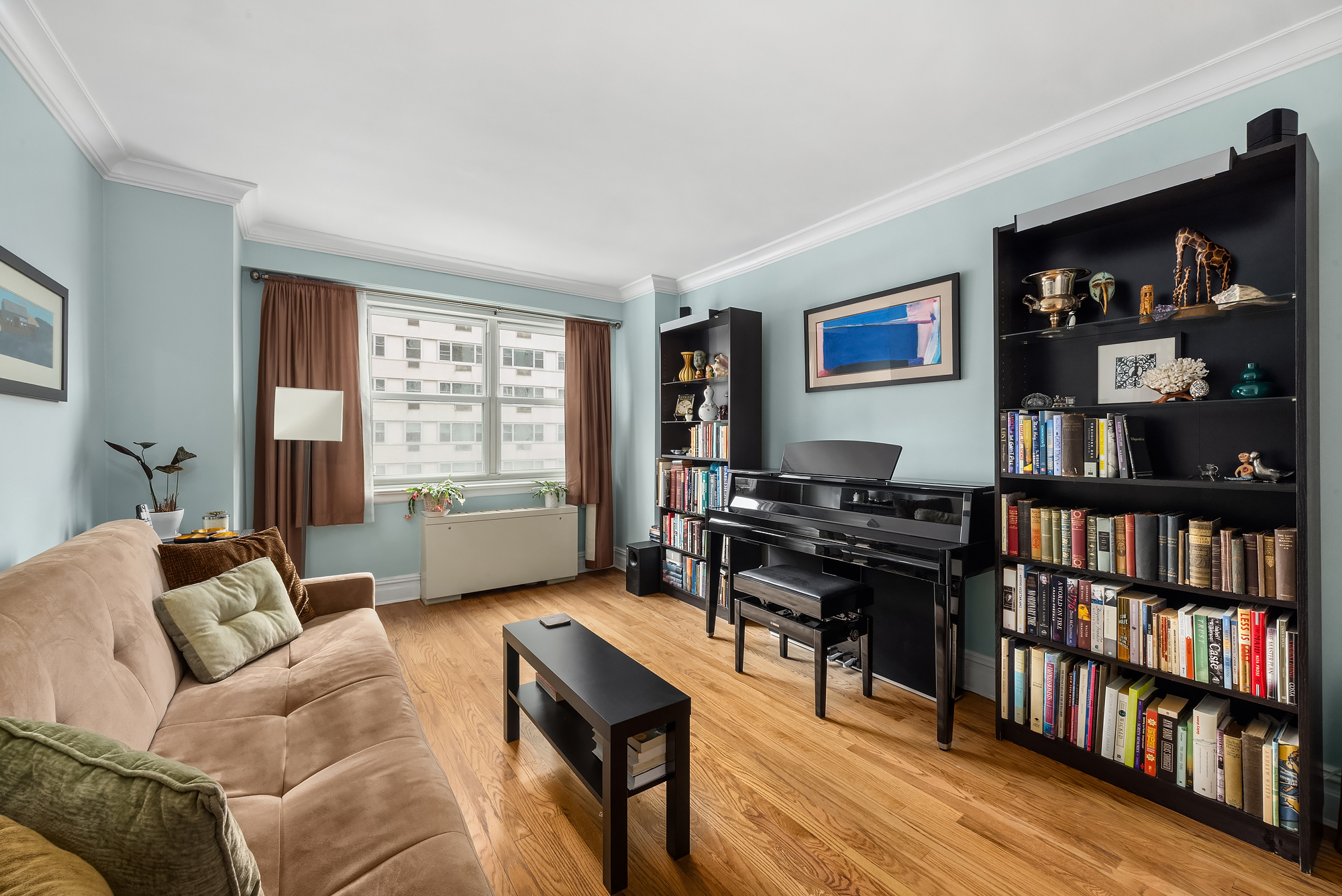 101 West 12th Street, Unit 8N Manhattan, NY 10011 - Photo 10 of 17 a living room with furniture and a book shelf