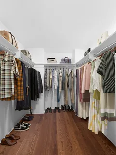 a view of walk in closet with clothes and shoes