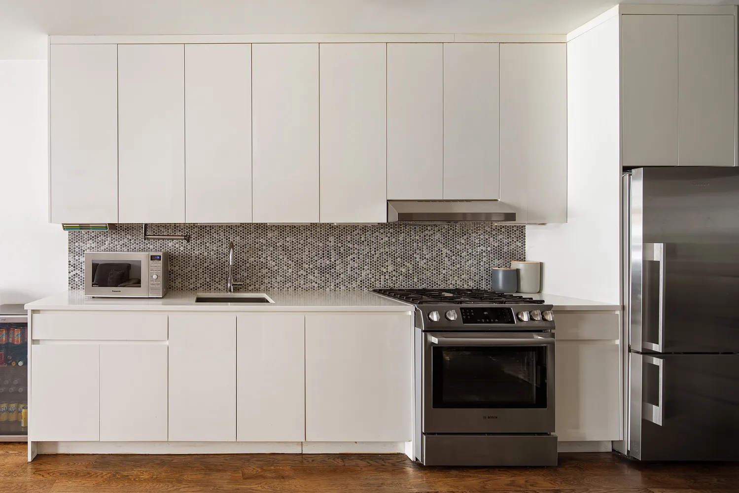 a kitchen with granite countertop white cabinets and stainless steel appliances