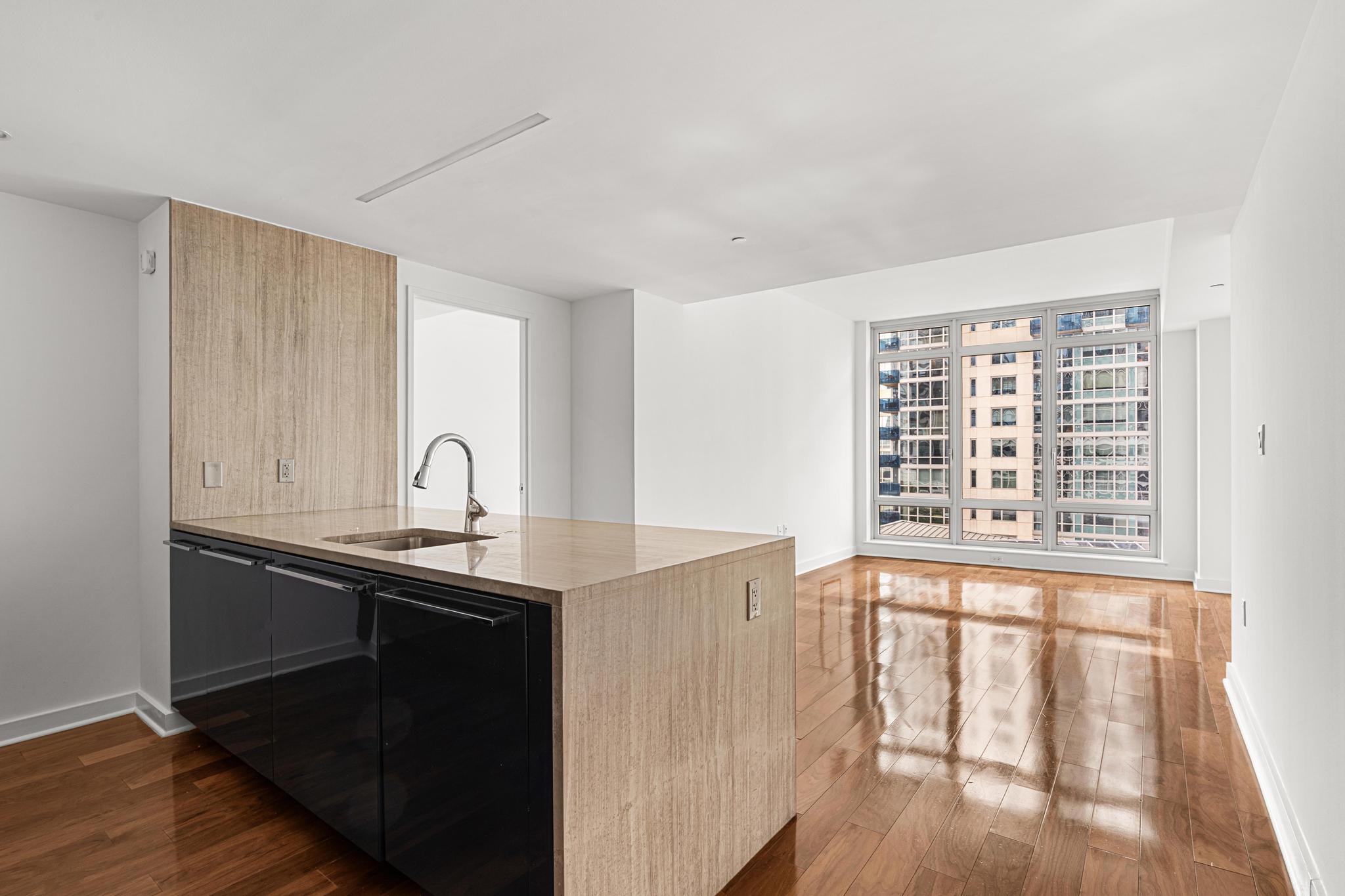 a view of a kitchen with granite countertop a sink and dishwasher with wooden floor