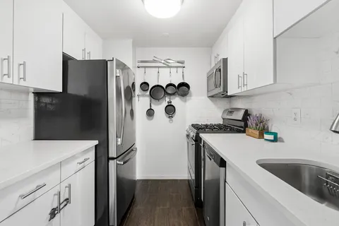 a kitchen with stainless steel appliances a refrigerator sink and cabinets