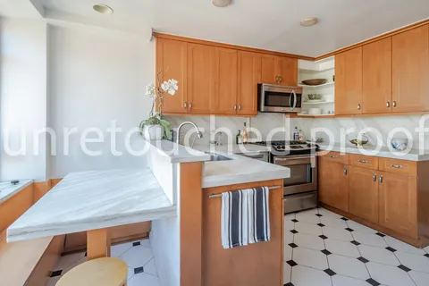 a kitchen with stainless steel appliances kitchen island granite countertop a sink a stove a microwave and cabinets