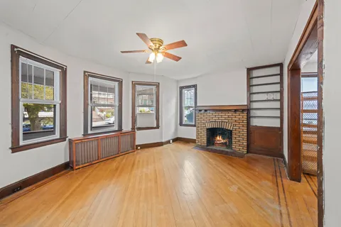 a view of an empty room with window and fireplace