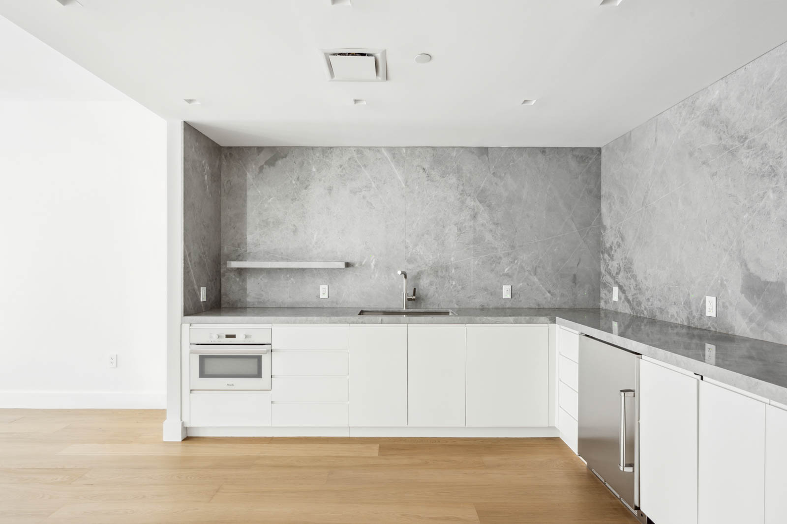 142 West 19th Street, Unit TH Manhattan, NY 10011 - Photo 8 of 10 a kitchen with granite countertop white cabinets and white appliances
