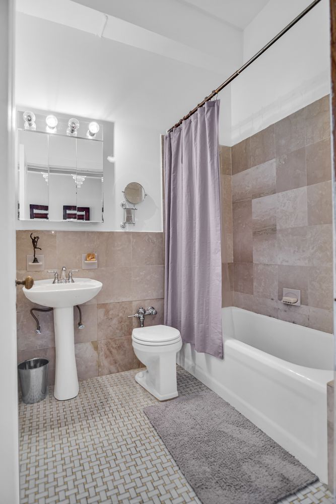 284 5th Avenue, Unit 5F Manhattan, NY 10001 - Photo 8 of 19 a bathroom with a sink toilet a mirror and shower