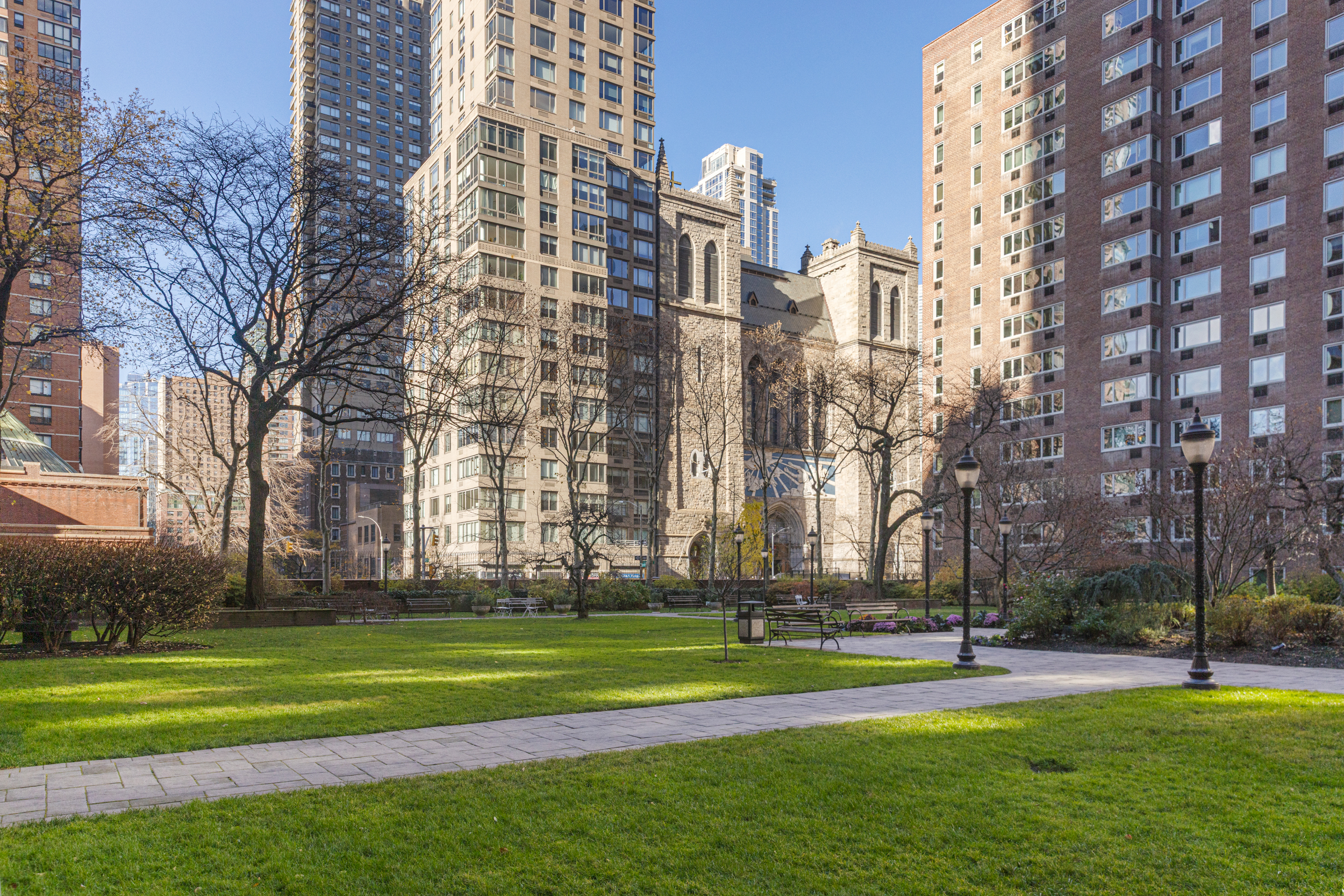 345 West 58th Street, Unit 4Y Manhattan, NY 10019 - Photo 10 of 12 a multi story building with trees in front of it