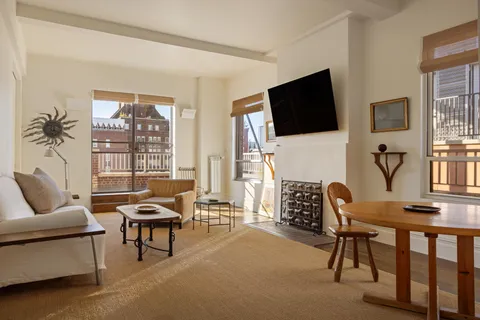 a living room with furniture a flat screen tv and a large window