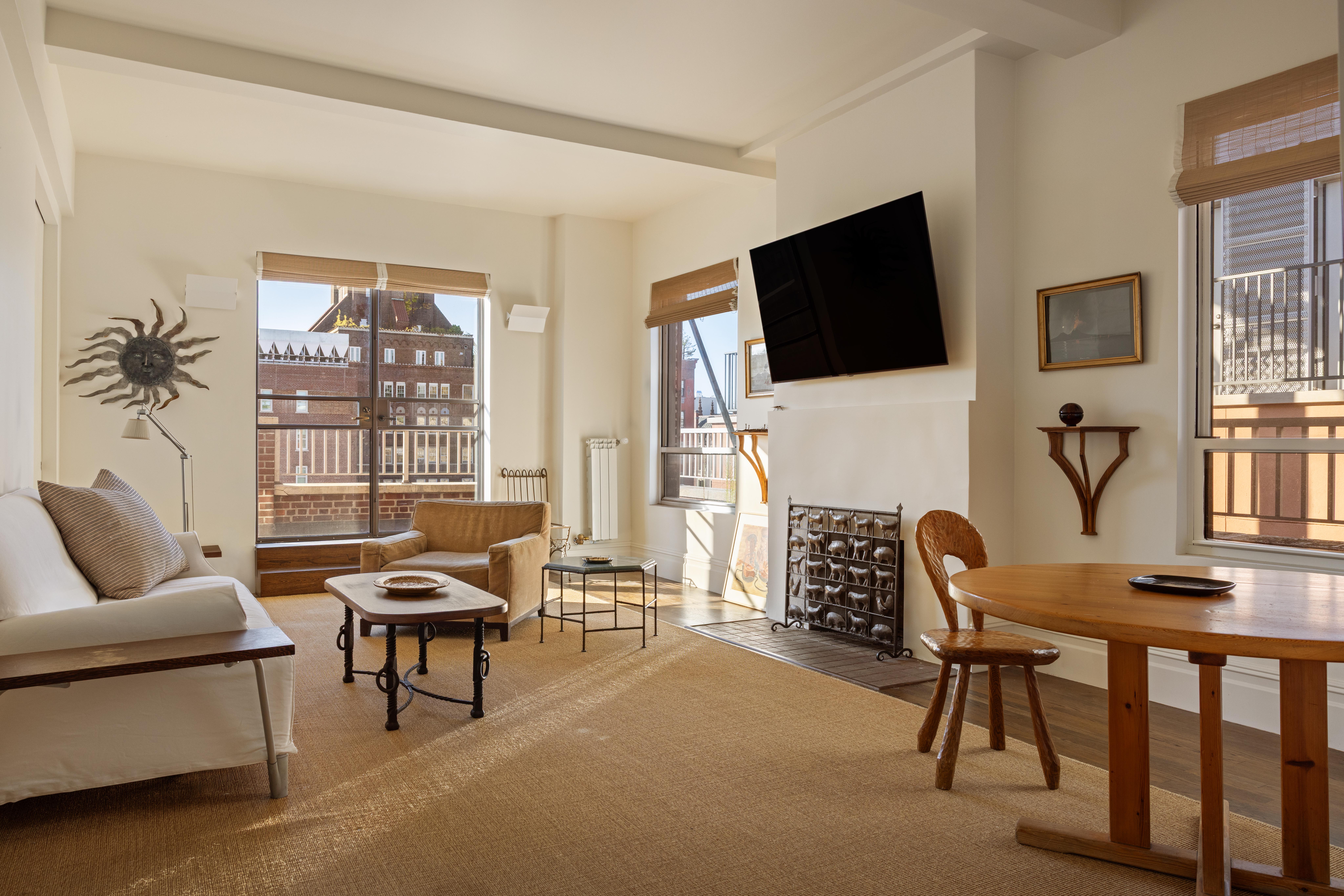 a living room with furniture a flat screen tv and a large window