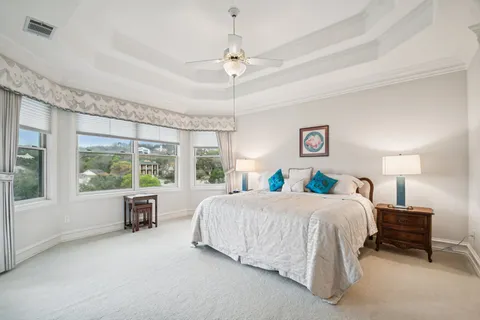 a bedroom with a bed and a large window
