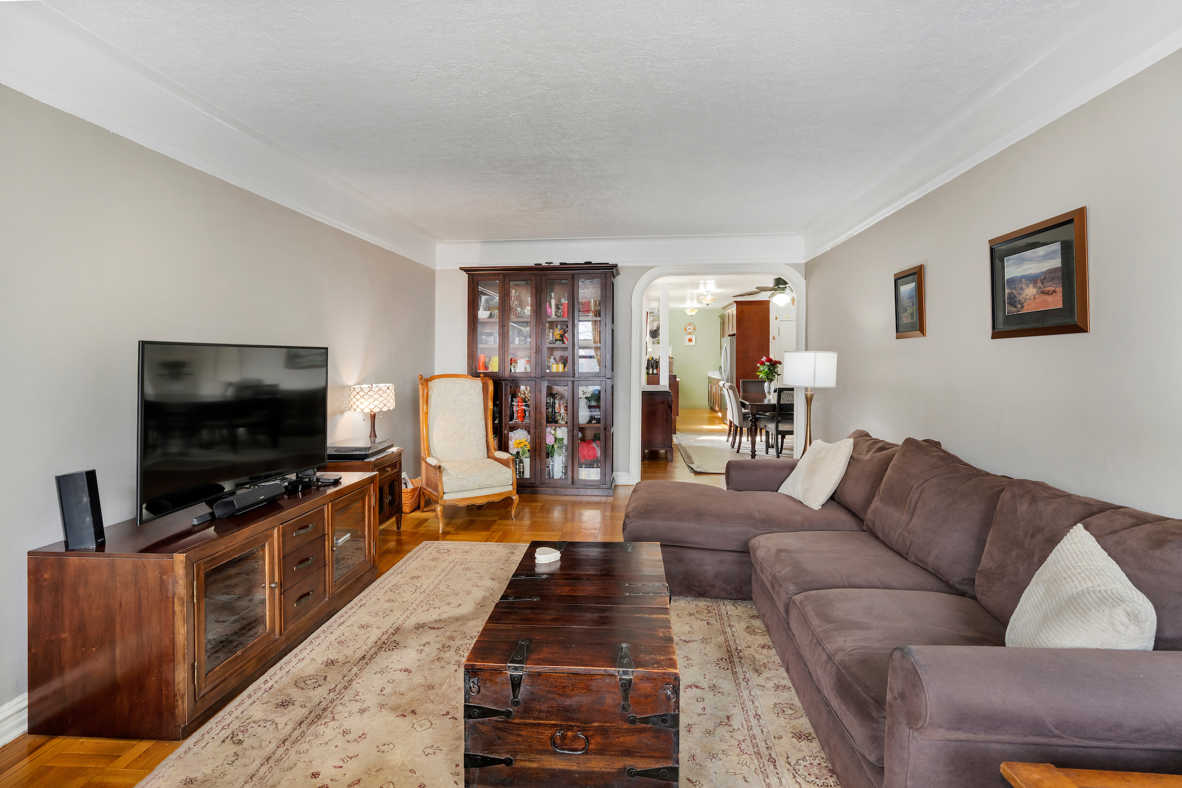 47-20 42nd Street, Unit 1H Queens, NY 11104 - Photo 3 of 11 a living room with furniture and a flat screen tv