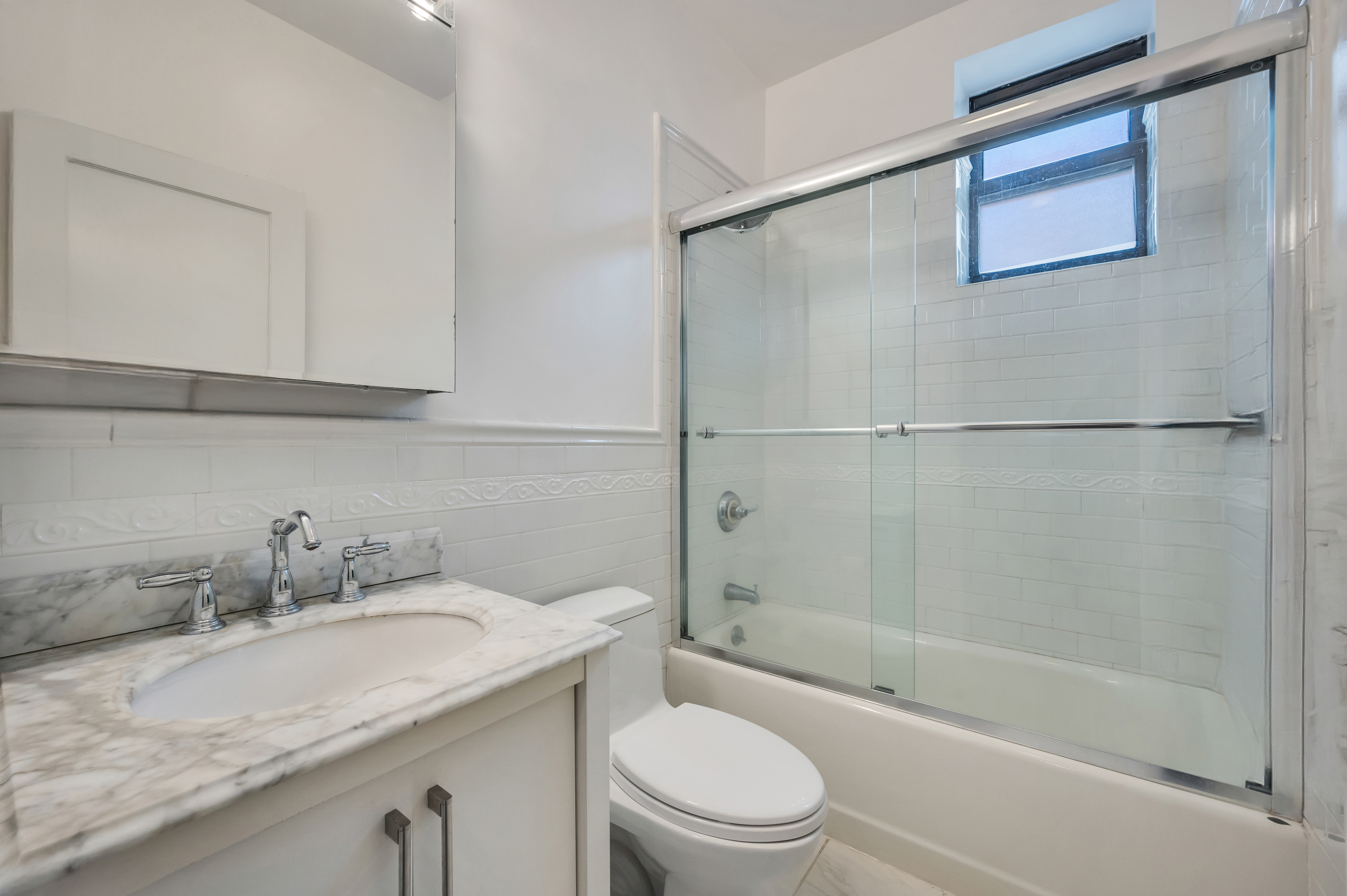 120 2nd Avenue, Unit 5A Manhattan, NY 10003 - Photo 11 of 13 a bathroom with a granite countertop sink mirror toilet and bathtub