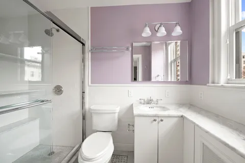 a bathroom with a toilet sink and mirror
