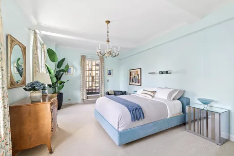 a spacious bedroom with a bed and a chandelier